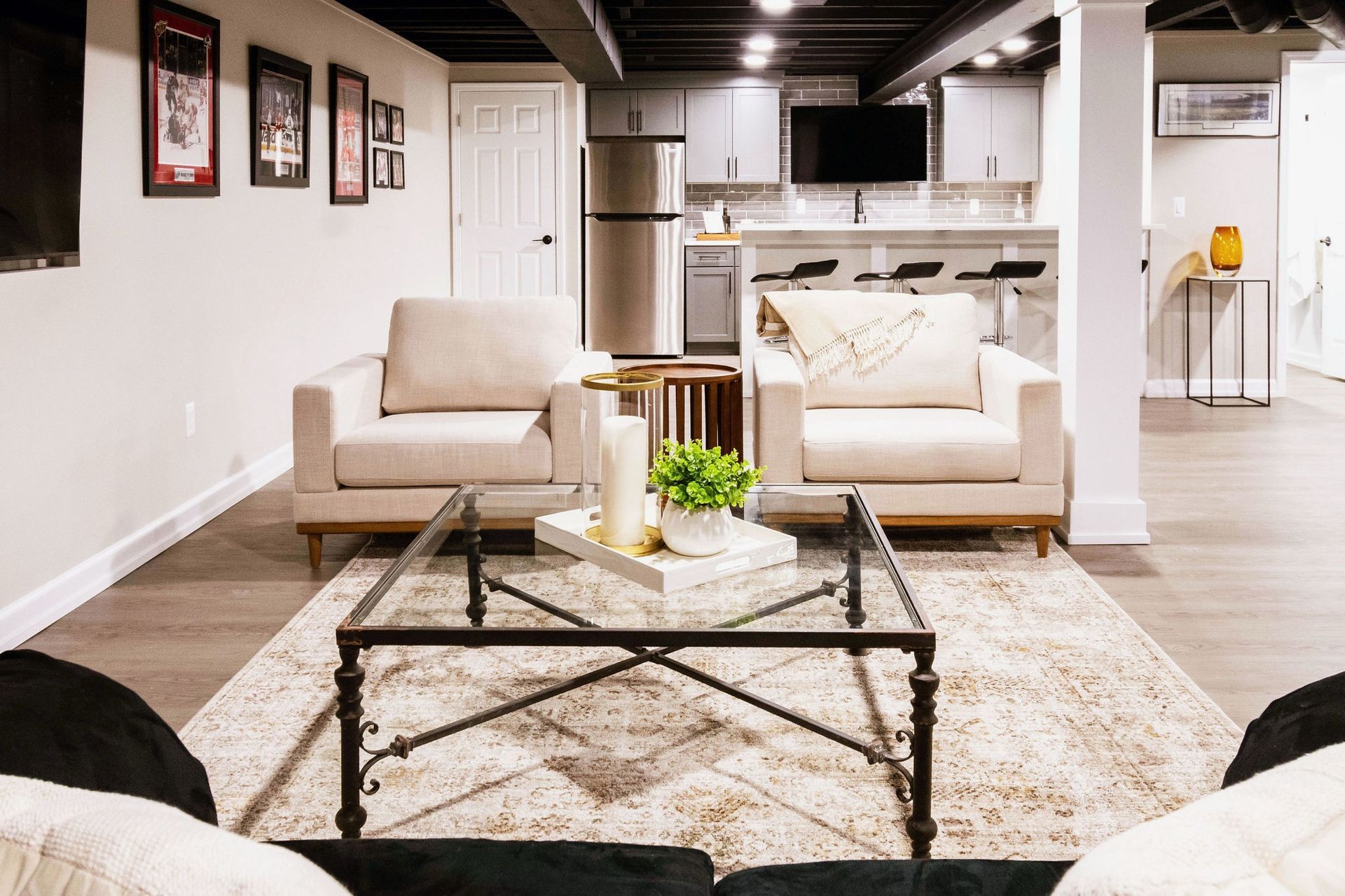Cozy living room with a central fireplace, built-in shelves, vaulted wood ceiling, and neutral-toned seating.