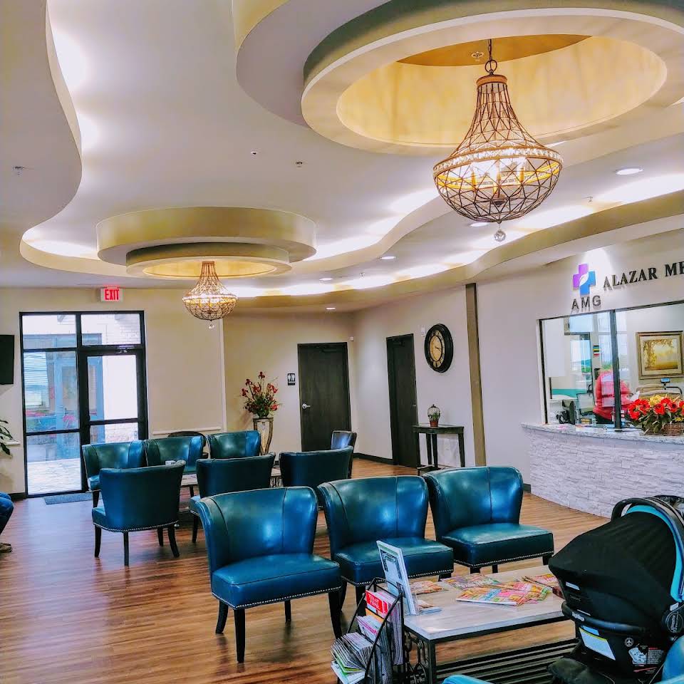 Waiting room with blue chairs, ornate chandeliers, and a reception desk.