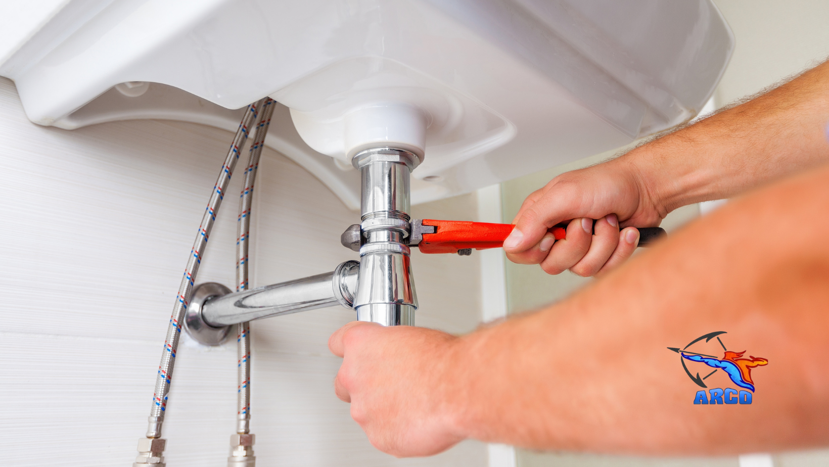 A man is fixing a sink with a wrench.
