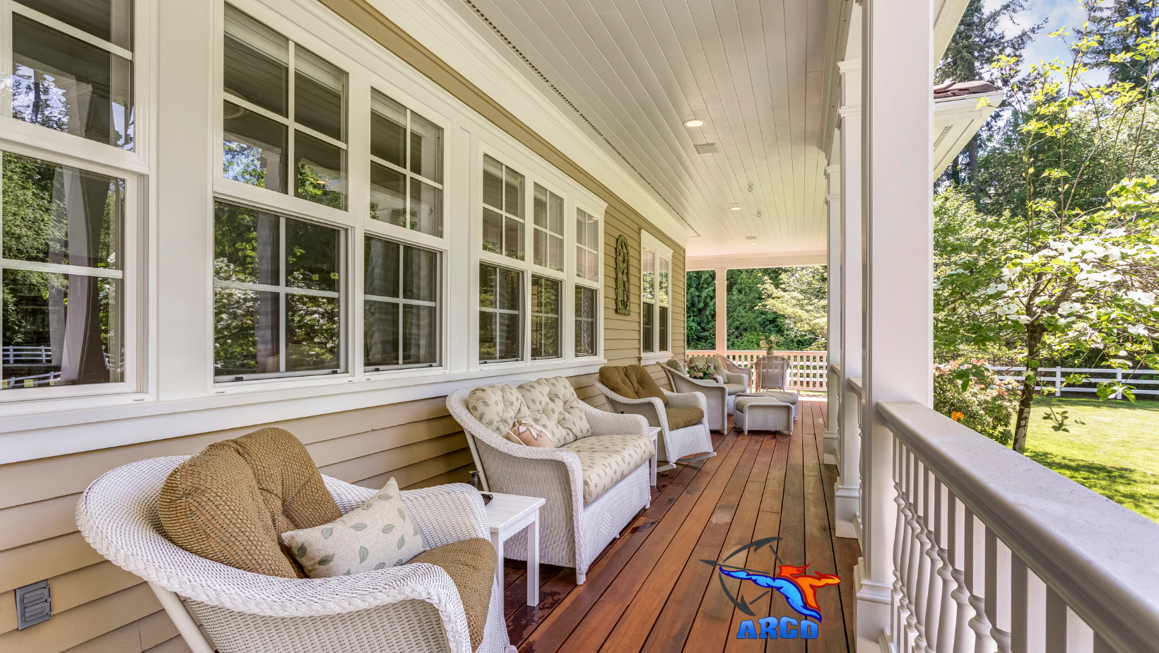 A large porch with wicker chairs , a couch , and a table.