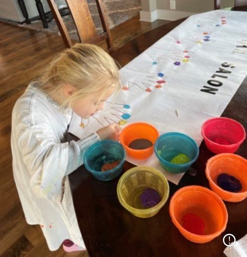 A person painting on a white banner labeled