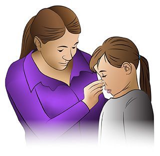 A person wearing a purple shirt gently pinching the bridge of another person's nose to stop a nosebleed.