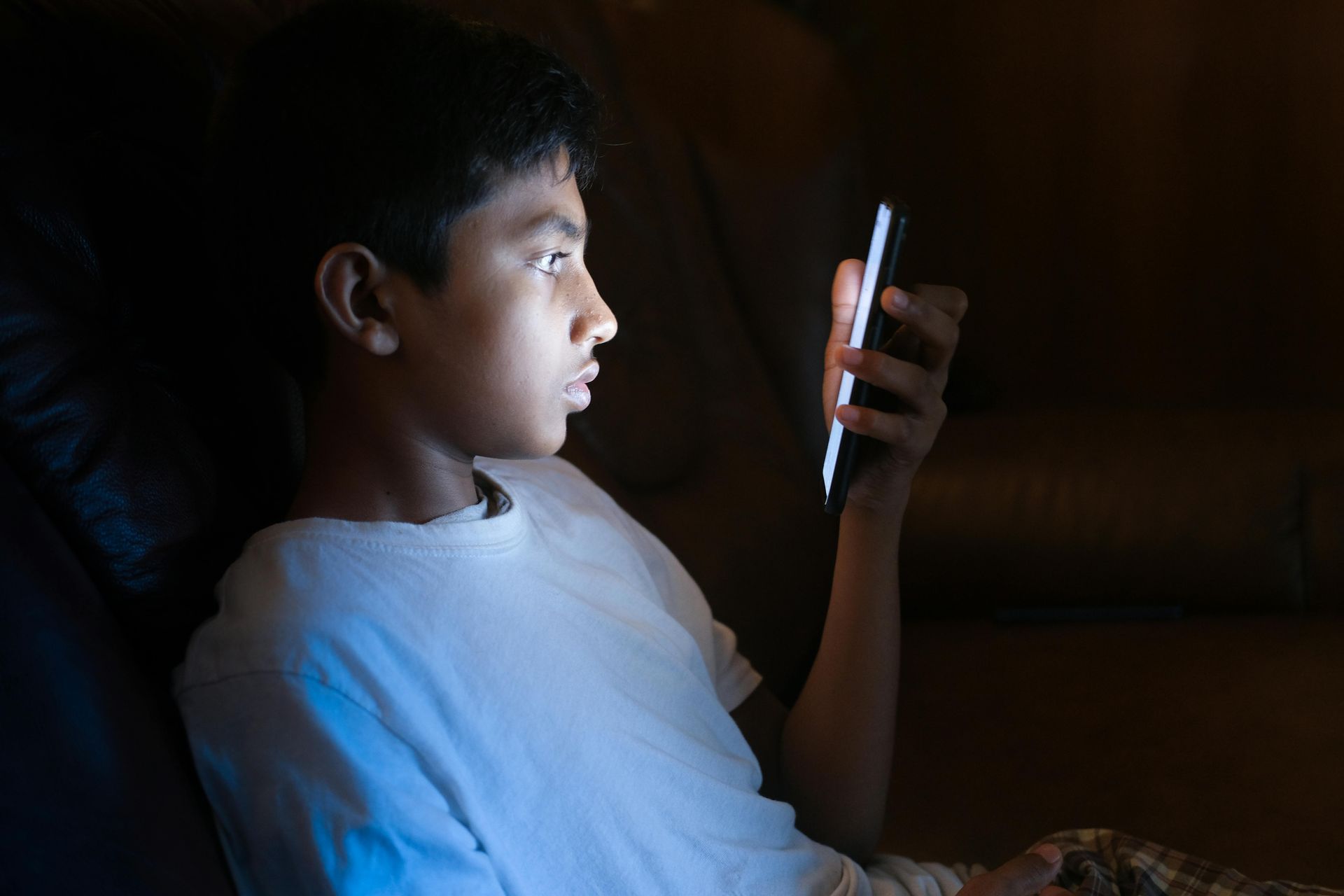 teen in bed with a cell phone