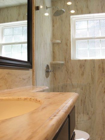 A bathroom with a toilet a sink and a mirror.