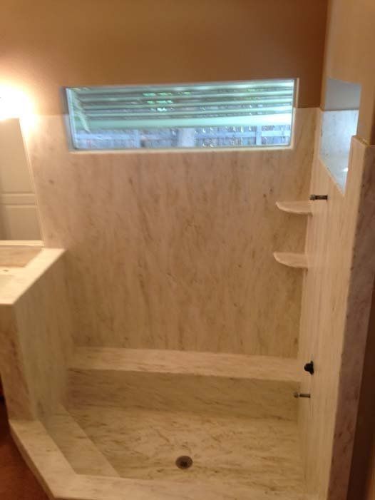 A bathroom with a shower , sink , and window.