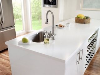 A kitchen counter with a sink and a sponge on it.