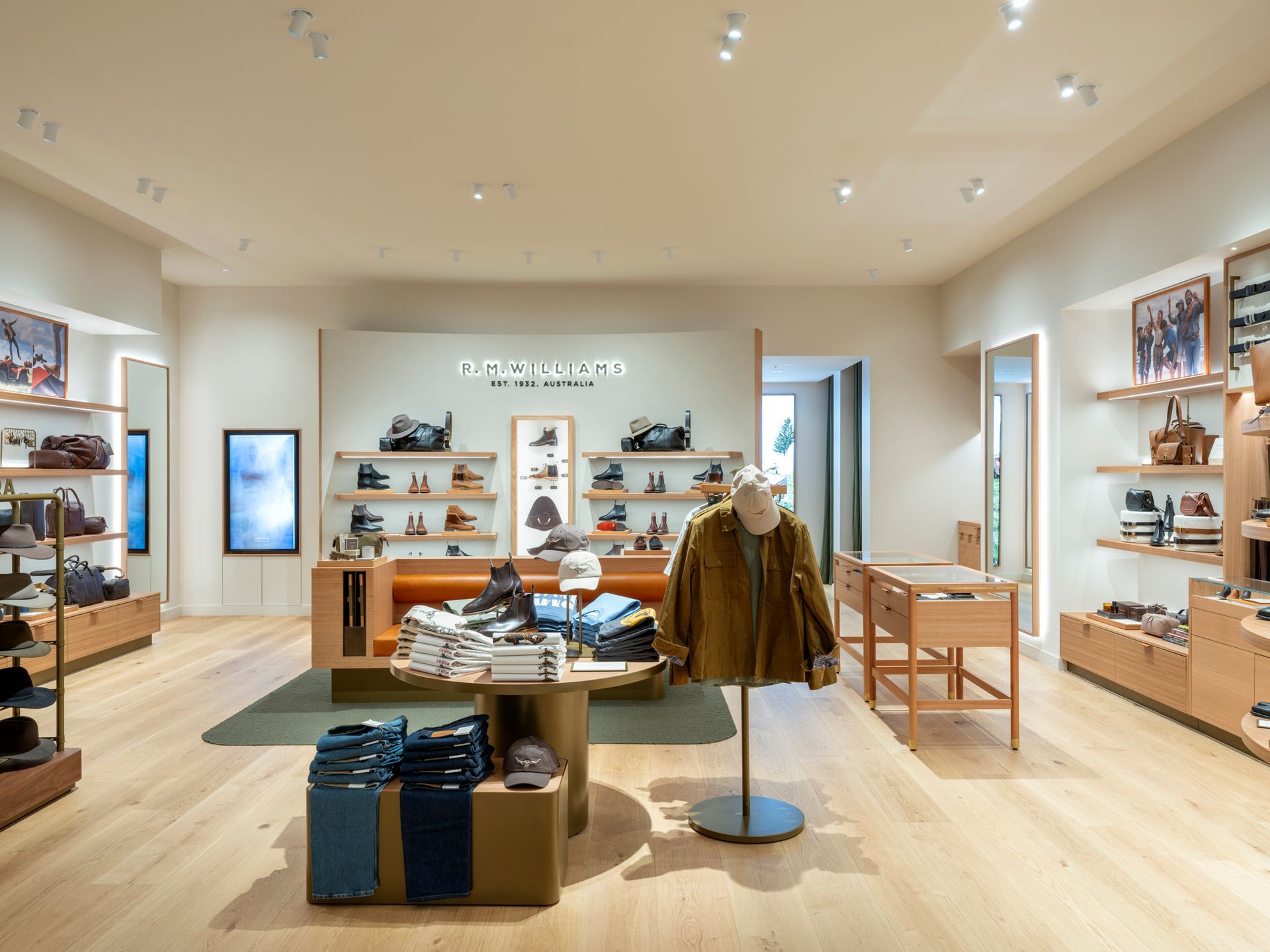 Interior of a clothing store with wood floors, shelves, and displays of apparel and shoes.