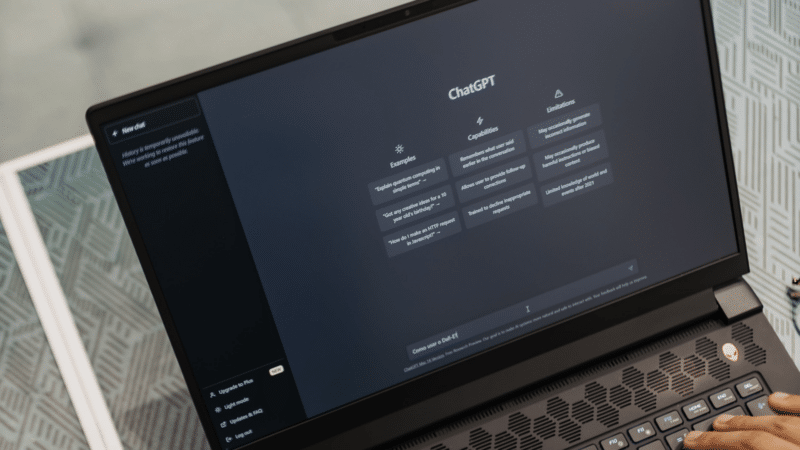 Laptop screen displaying ChatGPT interface, with a user's hands on the keyboard.