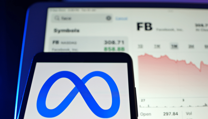 A smartphone and tablet displaying the Meta logo and stock chart, showing stock decline.