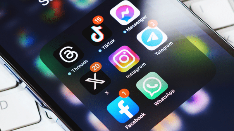 Smartphone screen displaying app icons: Threads, TikTok, Instagram, Facebook, WhatsApp, Telegram, and Messenger, with notification badges.
