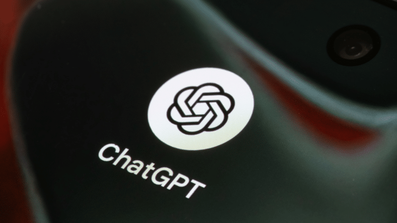 ChatGPT logo on a phone screen. The logo is a white, stylized knot on a black background.
