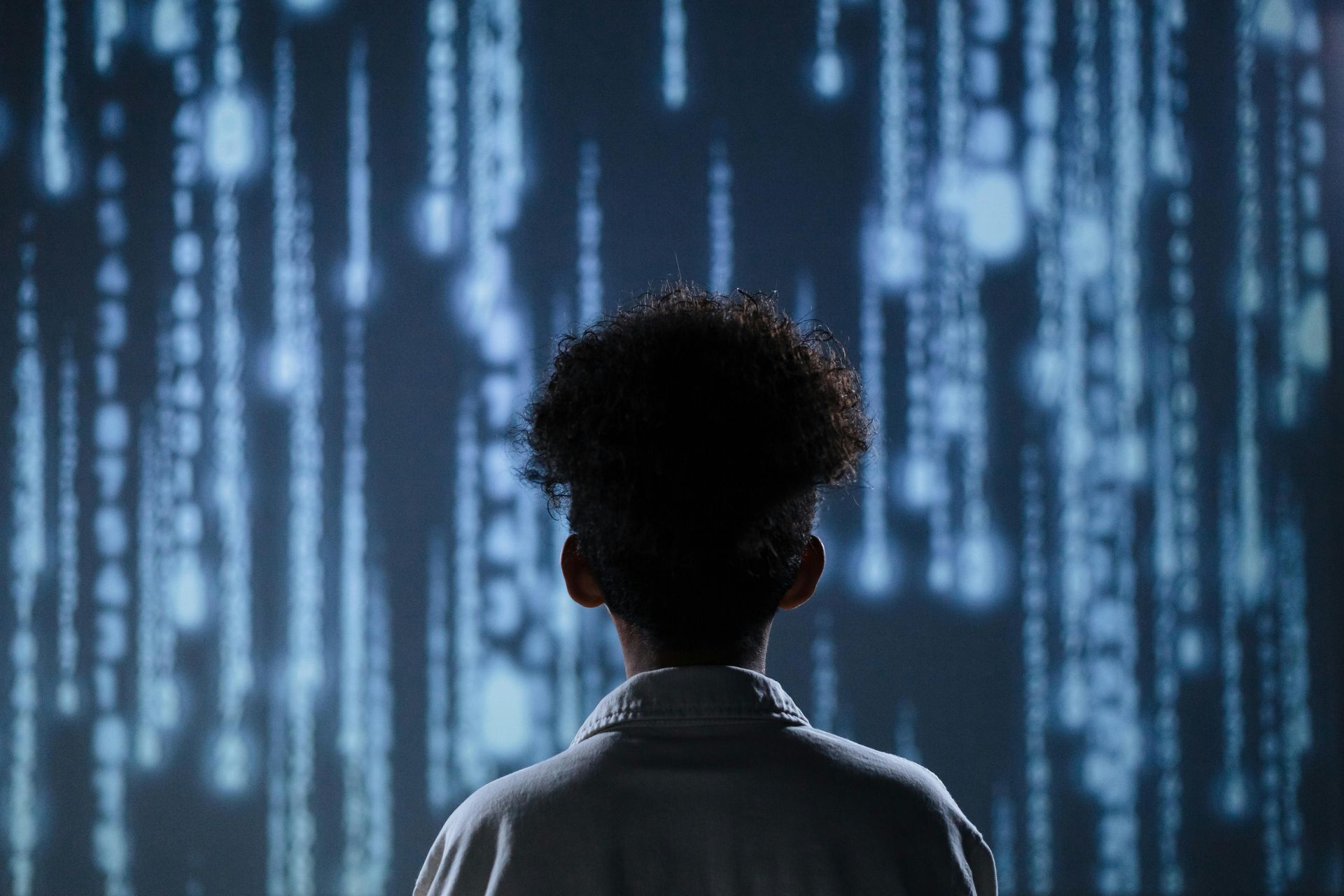 Person looking at a glowing blue data stream.