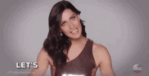 A woman with long, dark hair and a brown sparkly dress saying