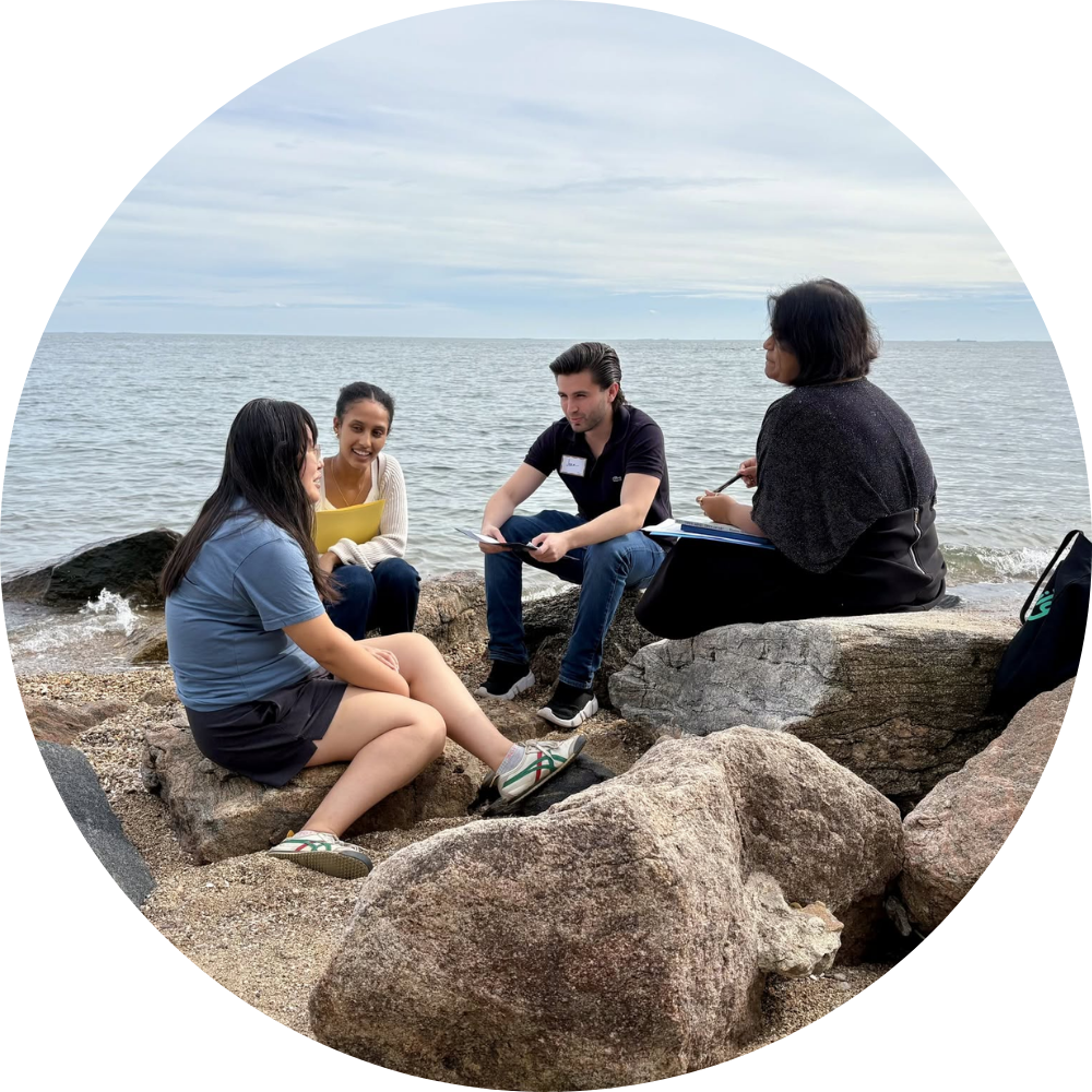 A group of students having conversation at the beach. 