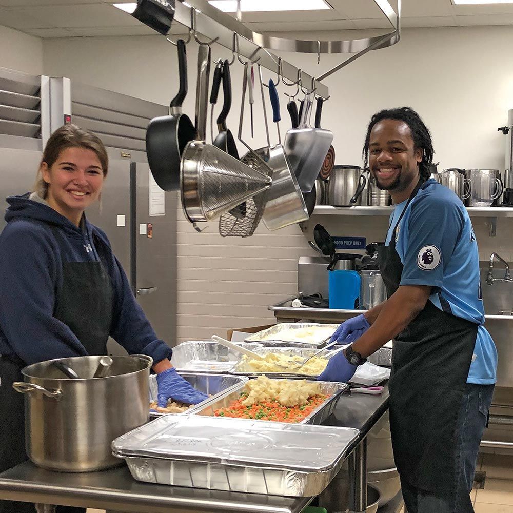 A man and a woman are preparing food in a kitchen.