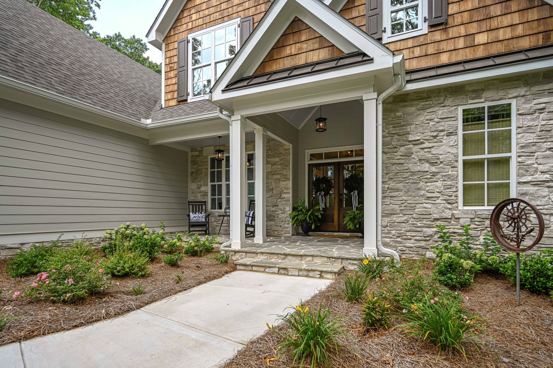 A large house with a large porch and a walkway leading to it.