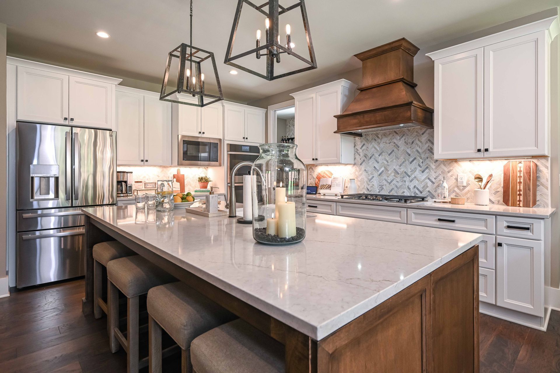 A kitchen with white cabinets , stainless steel appliances , and a large island.