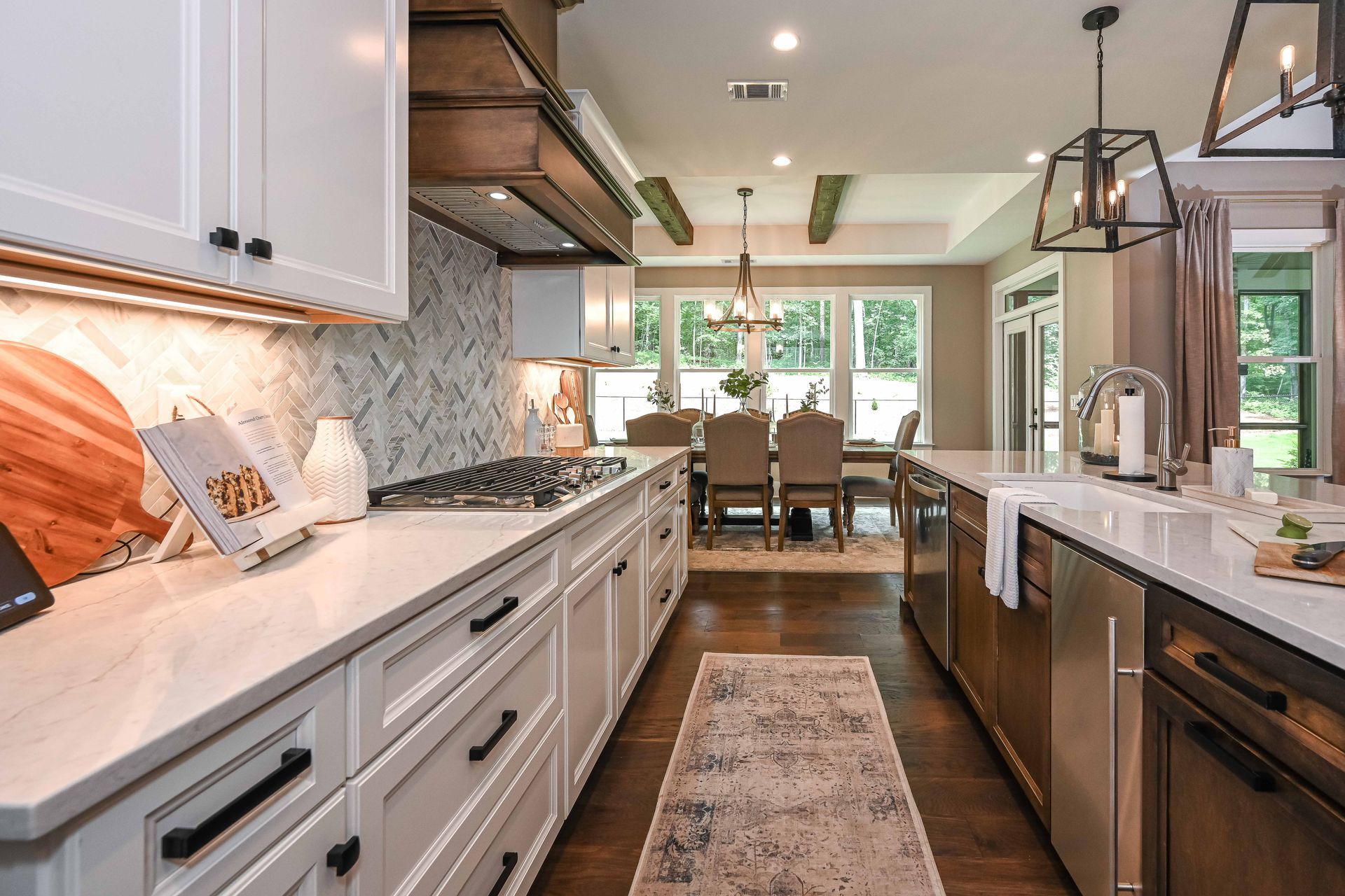 A kitchen with white cabinets and stainless steel appliances and a rug on the floor.