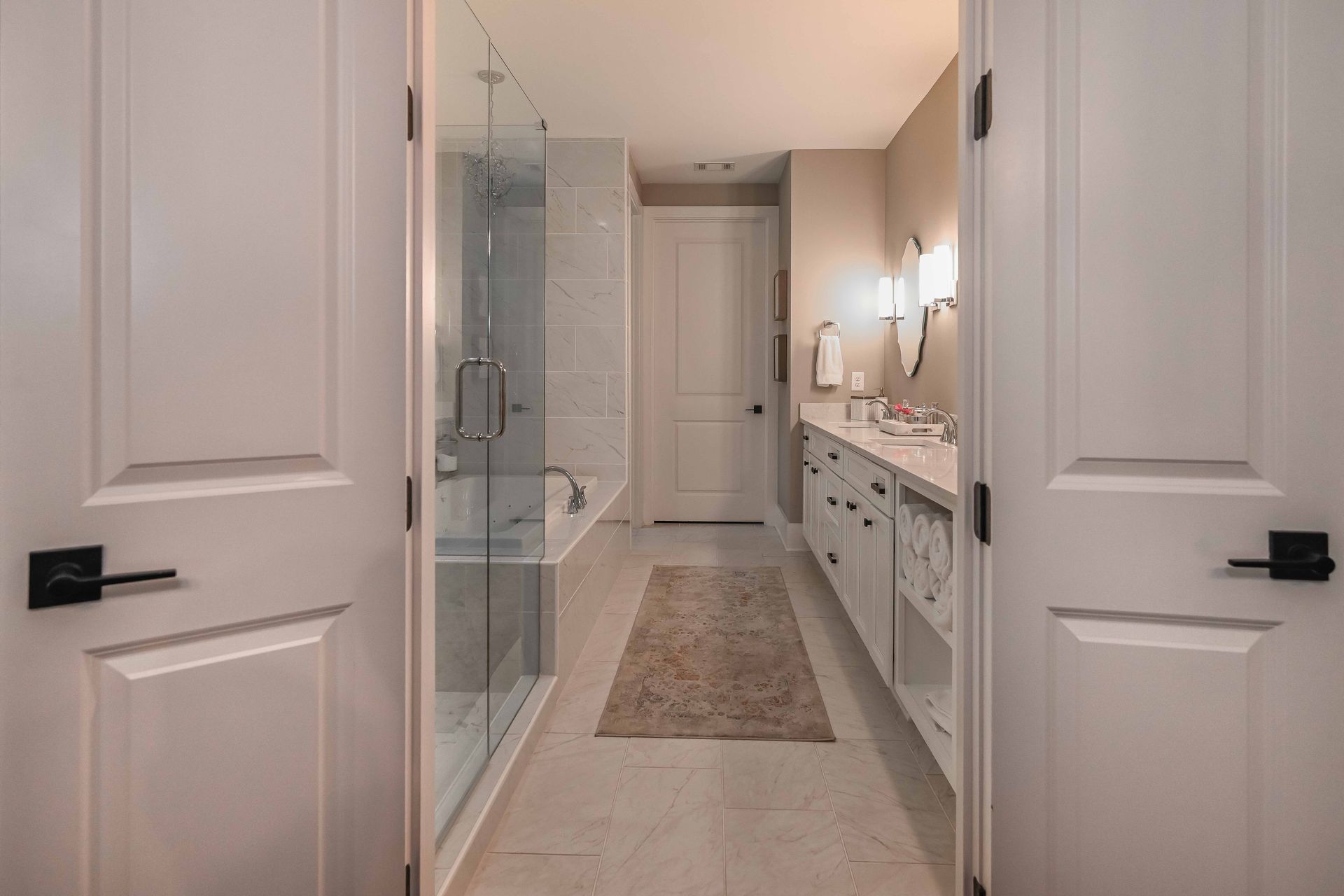 A bathroom with two sinks , a tub , and a walk in shower.
