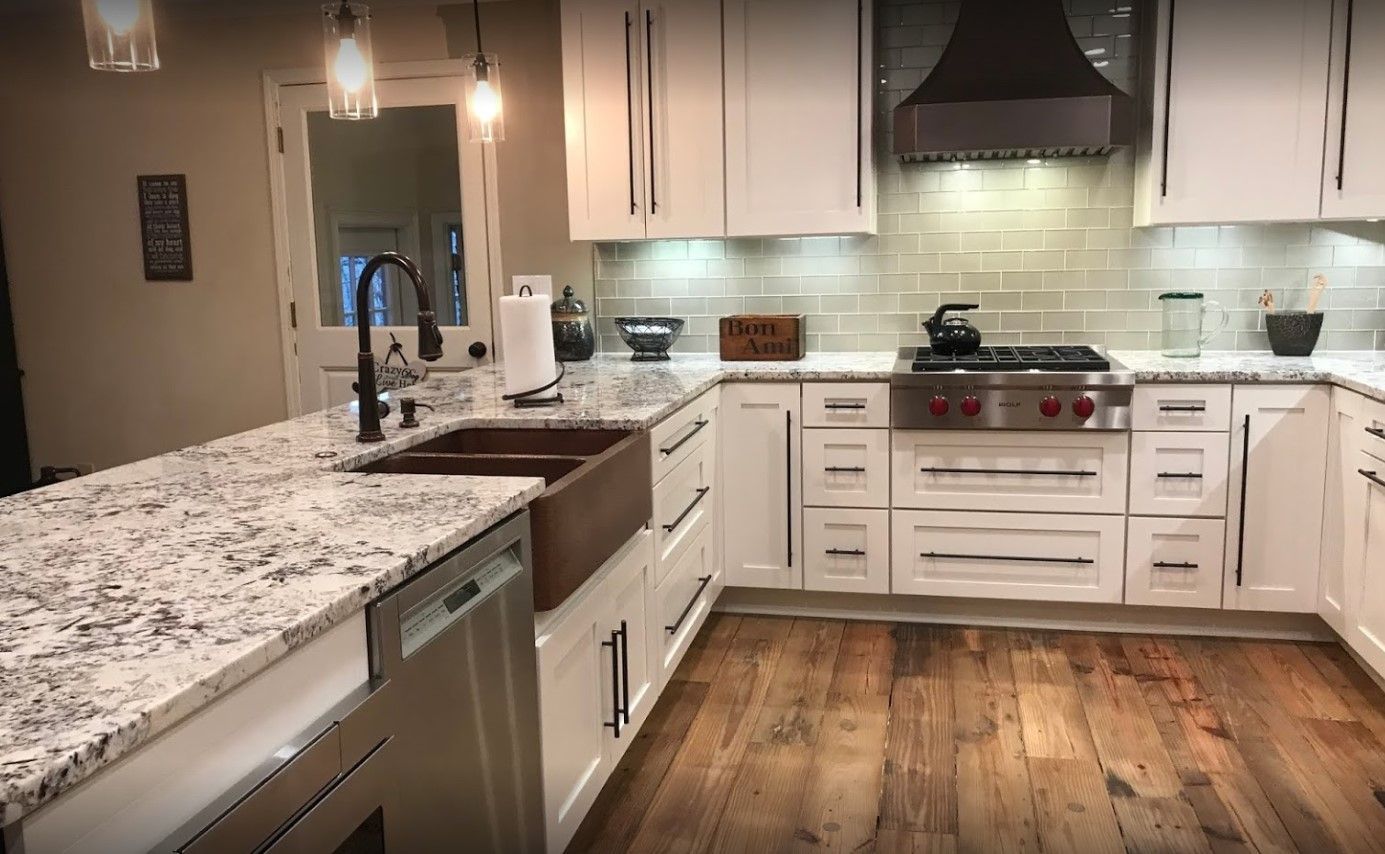 kitchen with marble countertop, white cabinets and black faucet