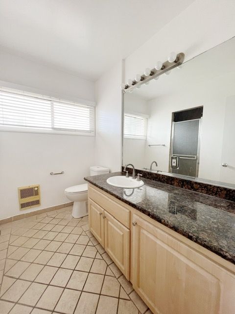 A bathroom with a toilet a sink and a large mirror