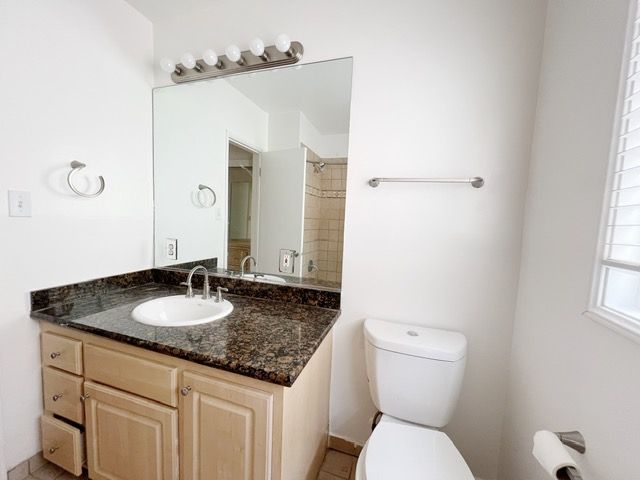 A bathroom with a toilet a sink and a mirror