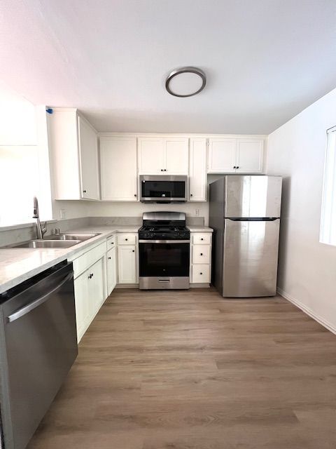 A kitchen with stainless steel appliances and white cabinets