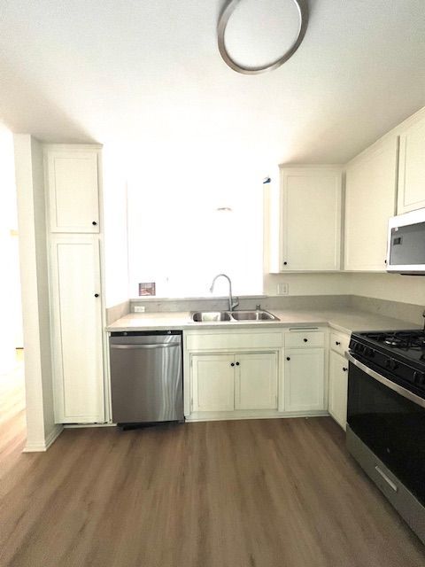 A kitchen with white cabinets and stainless steel appliances