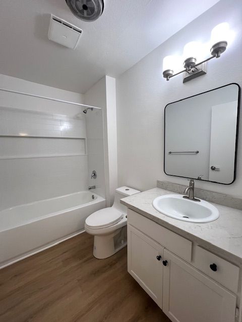 A bathroom with a sink , toilet , bathtub and mirror.