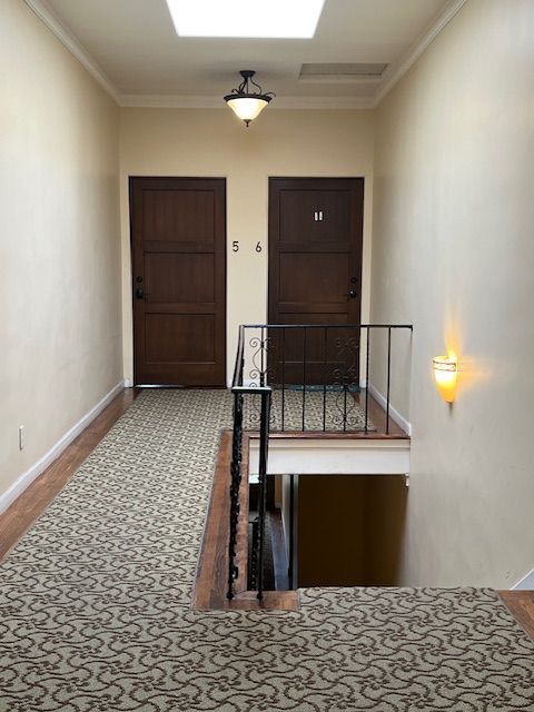 A hallway with two doors and a staircase leading to the second floor