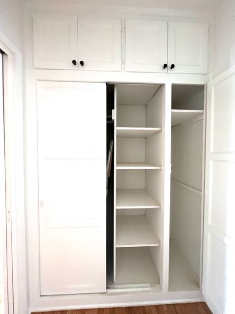 A white closet with shelves and sliding doors