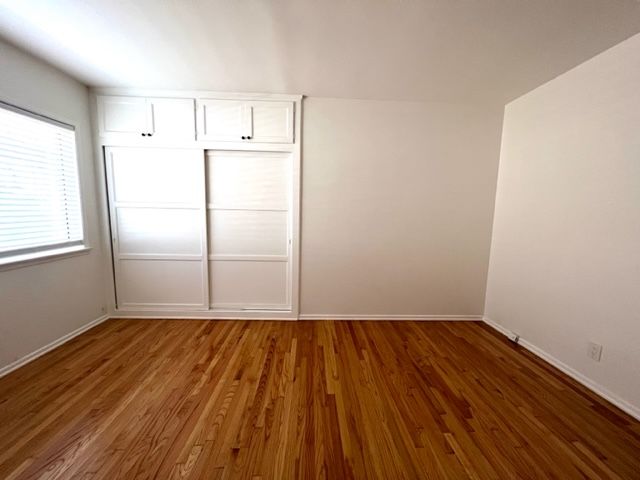 An empty room with hardwood floors and white walls