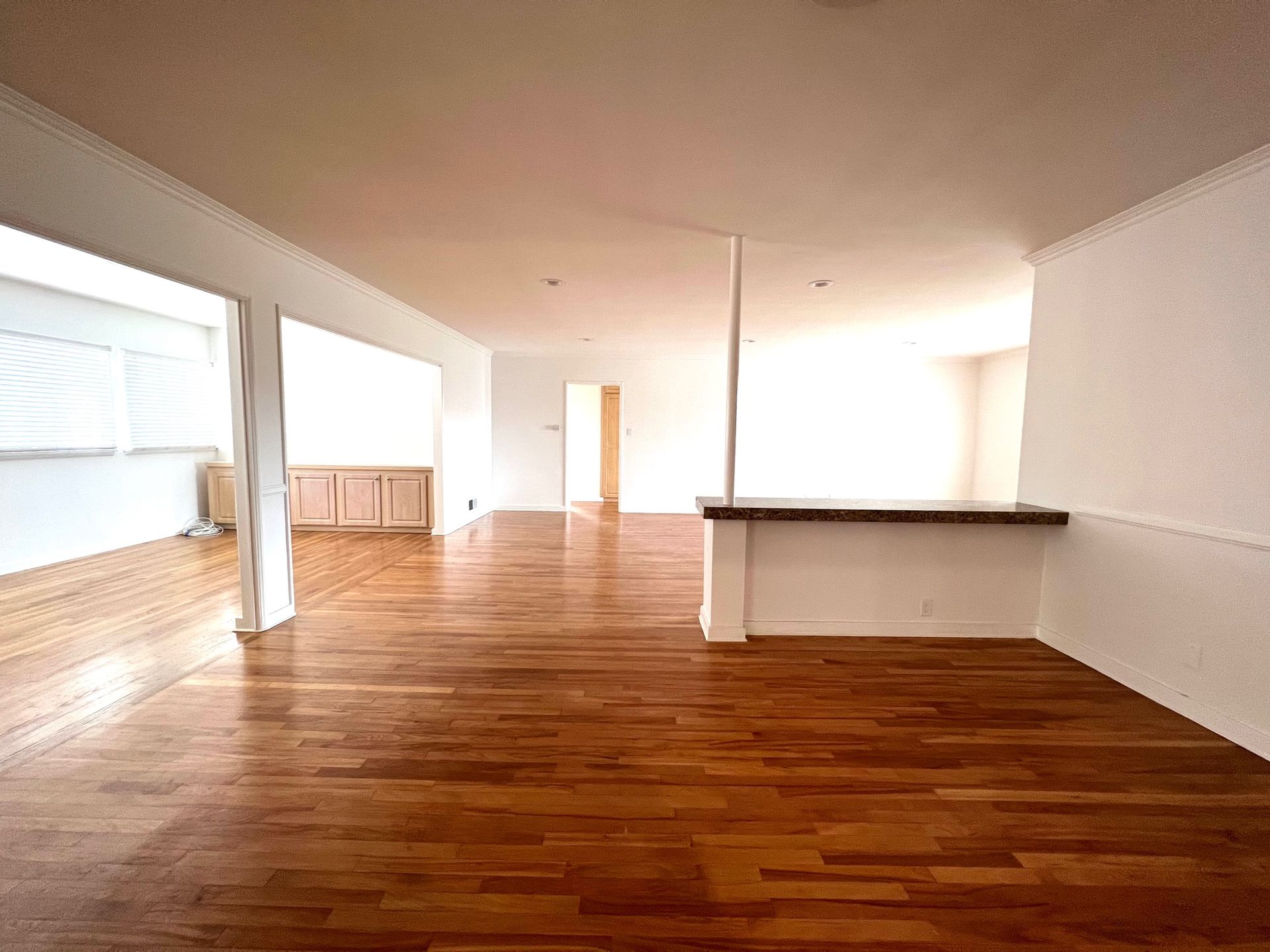 An empty room with hardwood floors and white walls