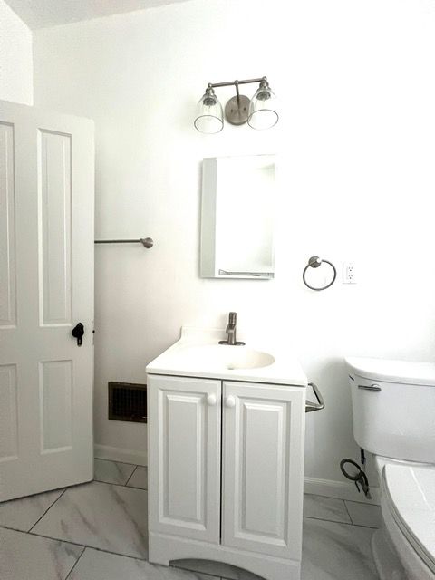 A bathroom with a sink , toilet and mirror