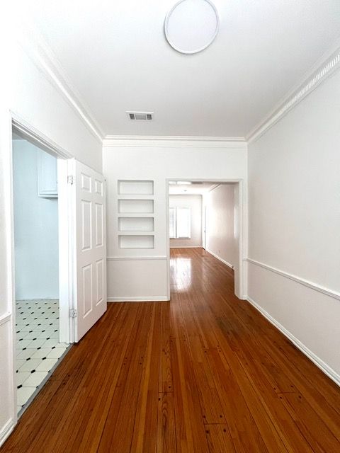 An empty hallway with hardwood floors and white walls