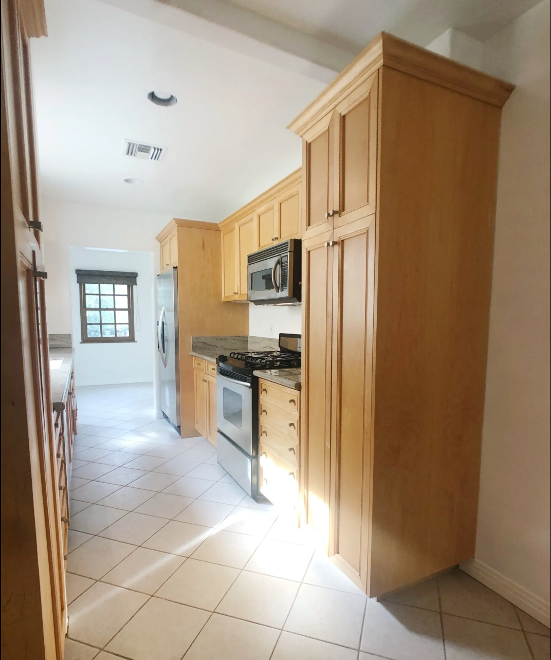 A kitchen with wooden cabinets and a stove top oven