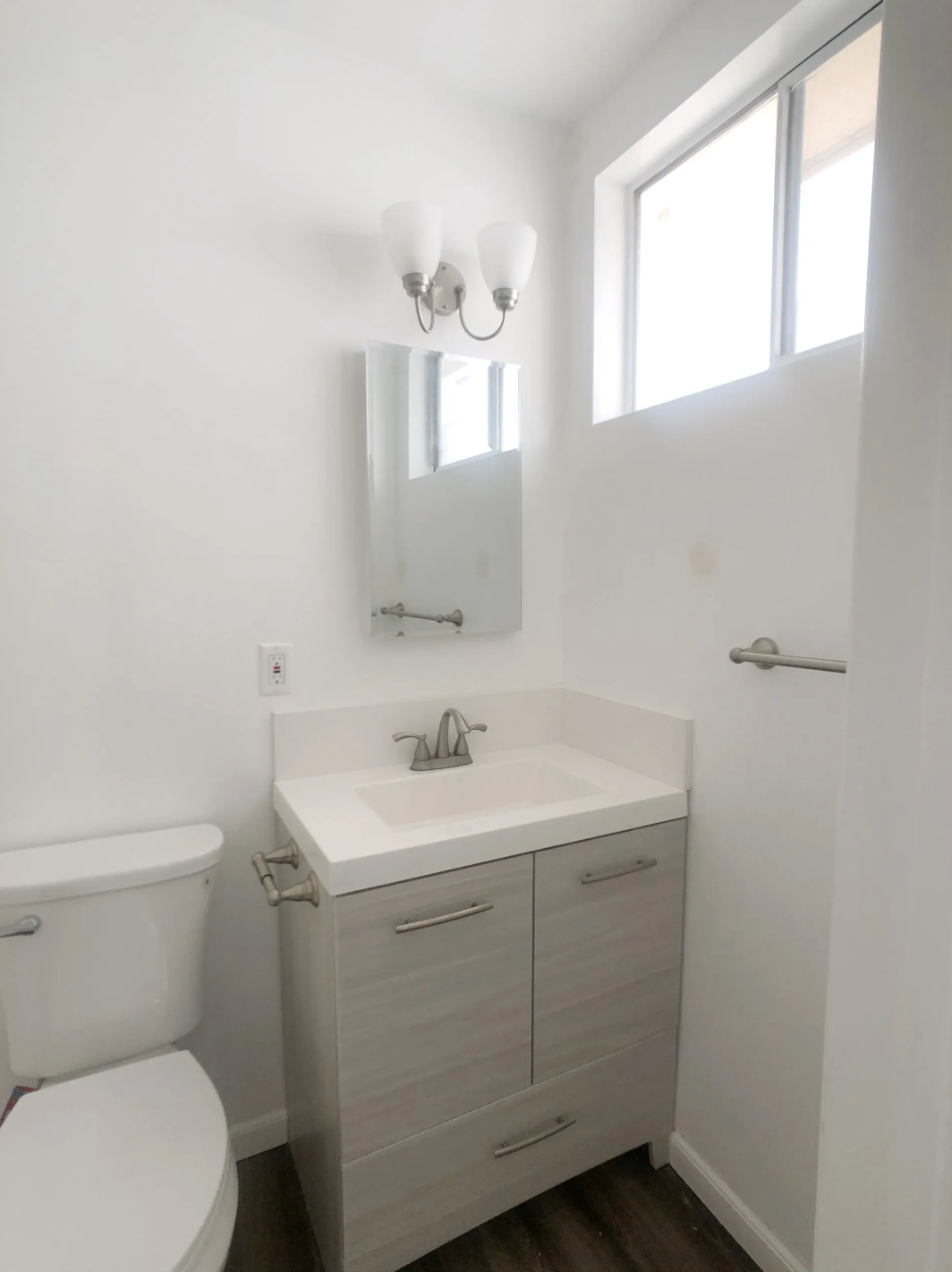 A bathroom with a toilet a sink and a mirror