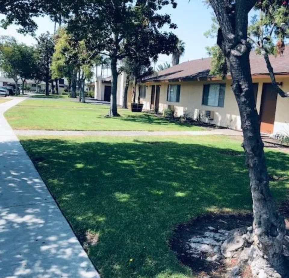A house with a lot of grass and trees in front of it