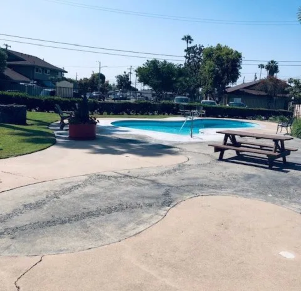 A swimming pool with a picnic table in front of it