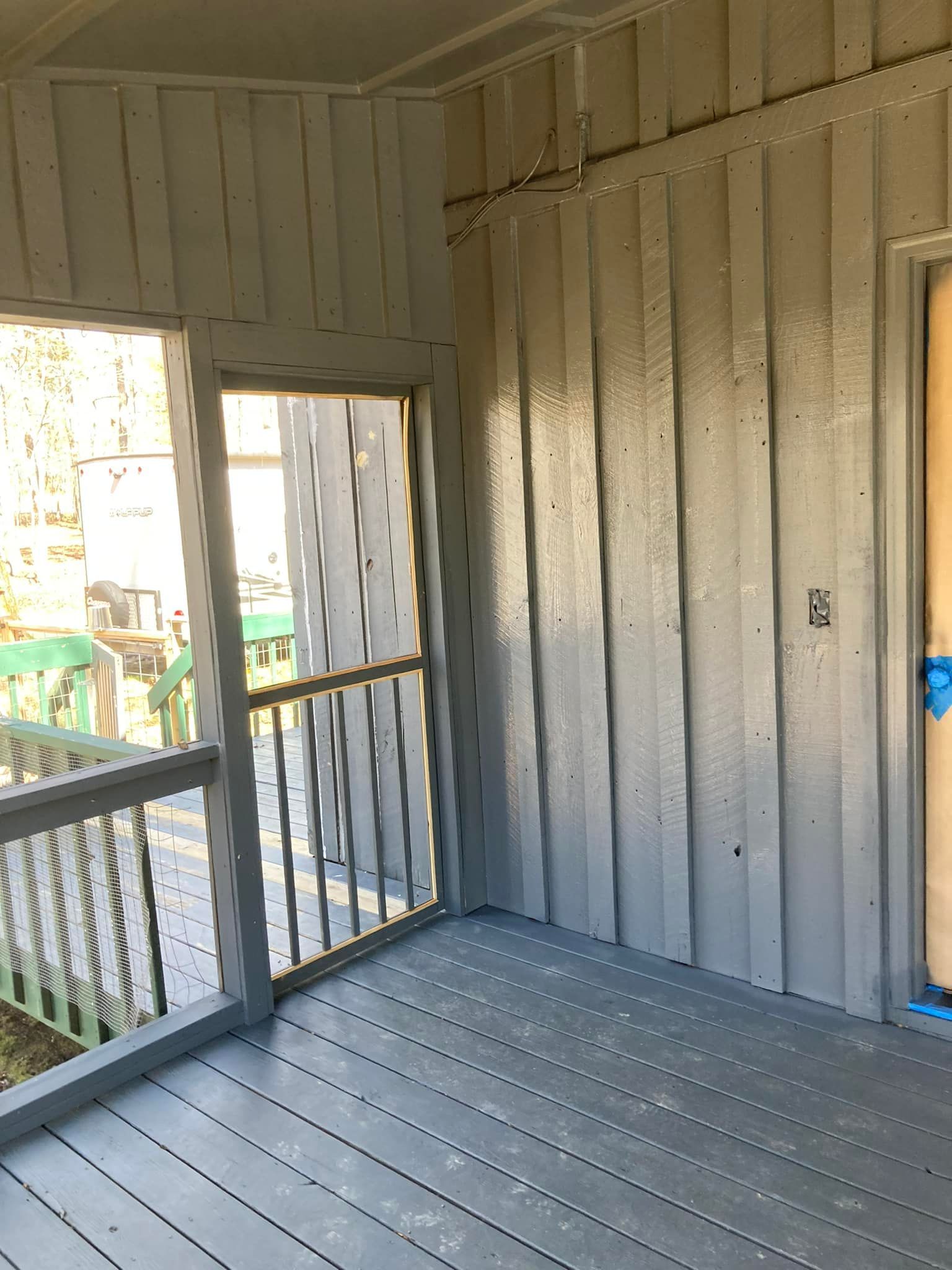 An empty room with a screened in porch and a door.