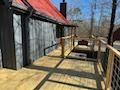 A wooden deck with a red roof in front of a house.