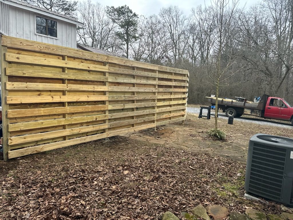 A wooden fence is being built in front of a house.