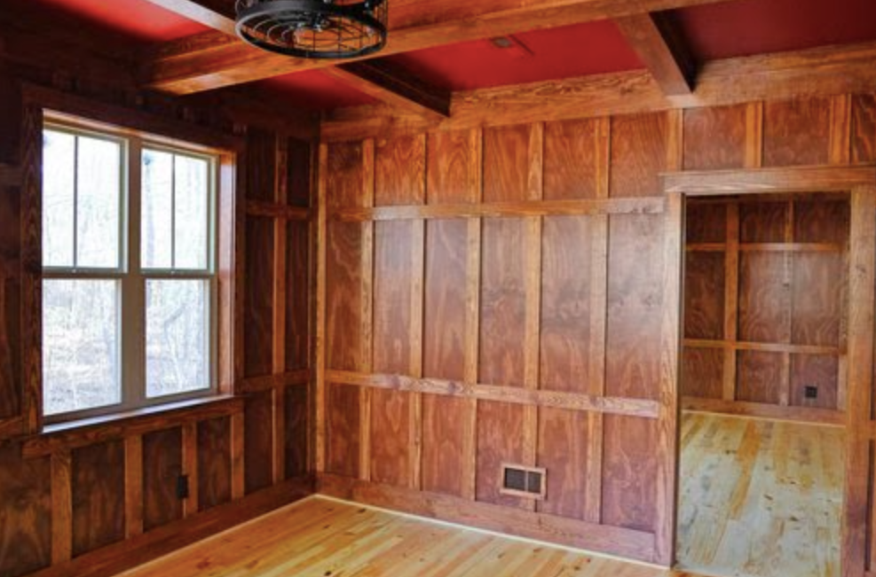 A room with wood paneling and a ceiling fan.