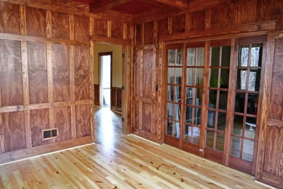 A room with wood paneling and sliding glass doors.
