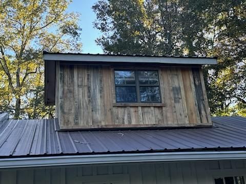 A wooden building with a metal roof and a window.