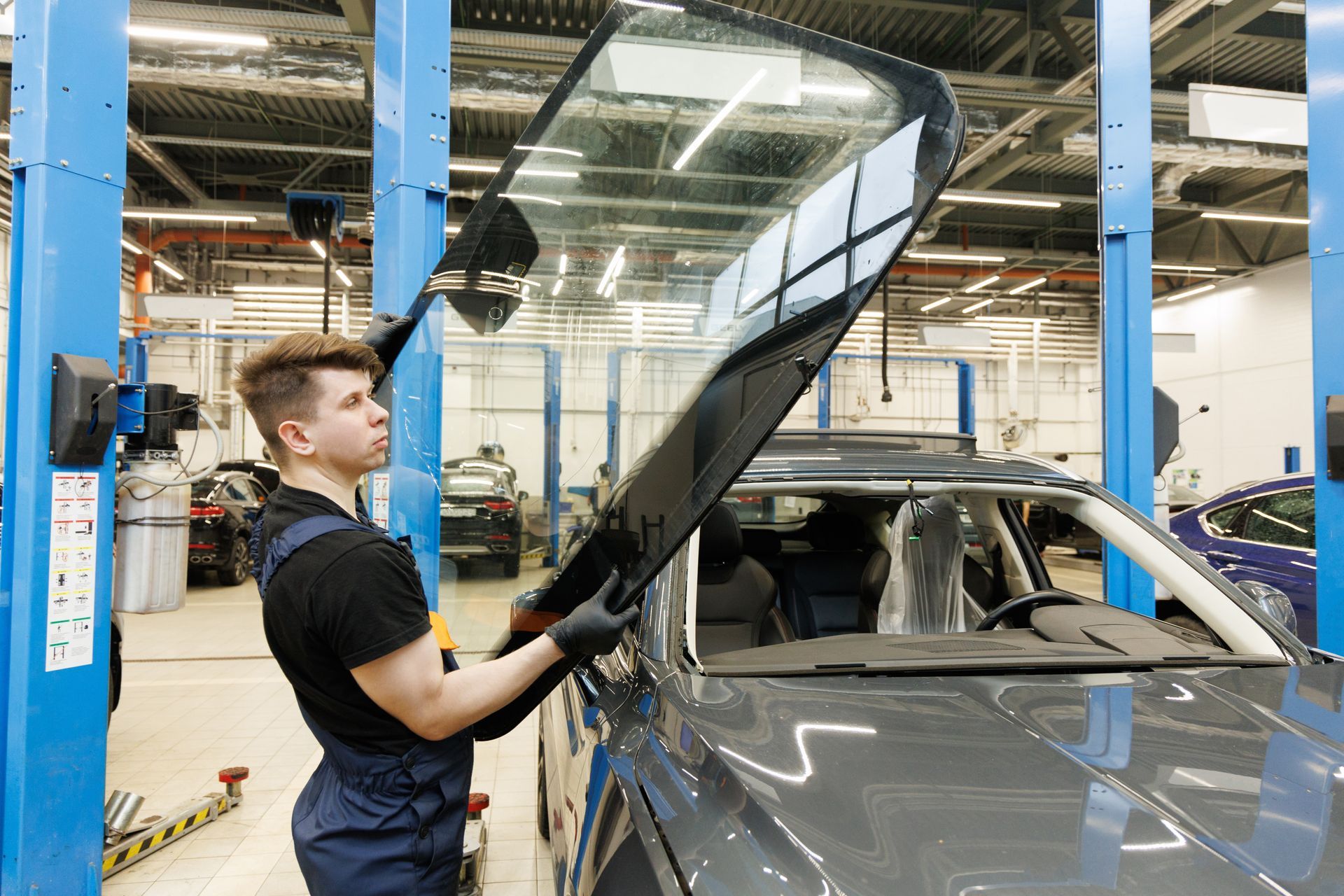 An auto glass expert replaces a damaged SUV windshield with precision.