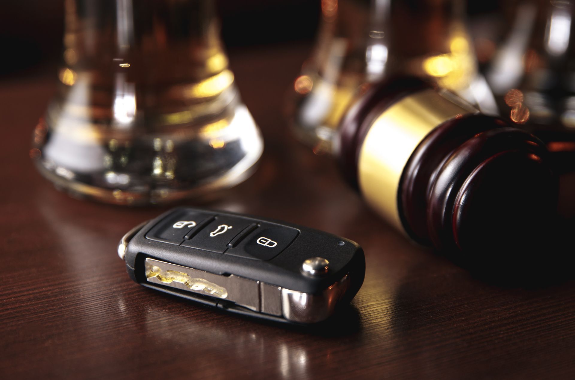 Drinking and driving concept. Car key on a wooden table, pub.