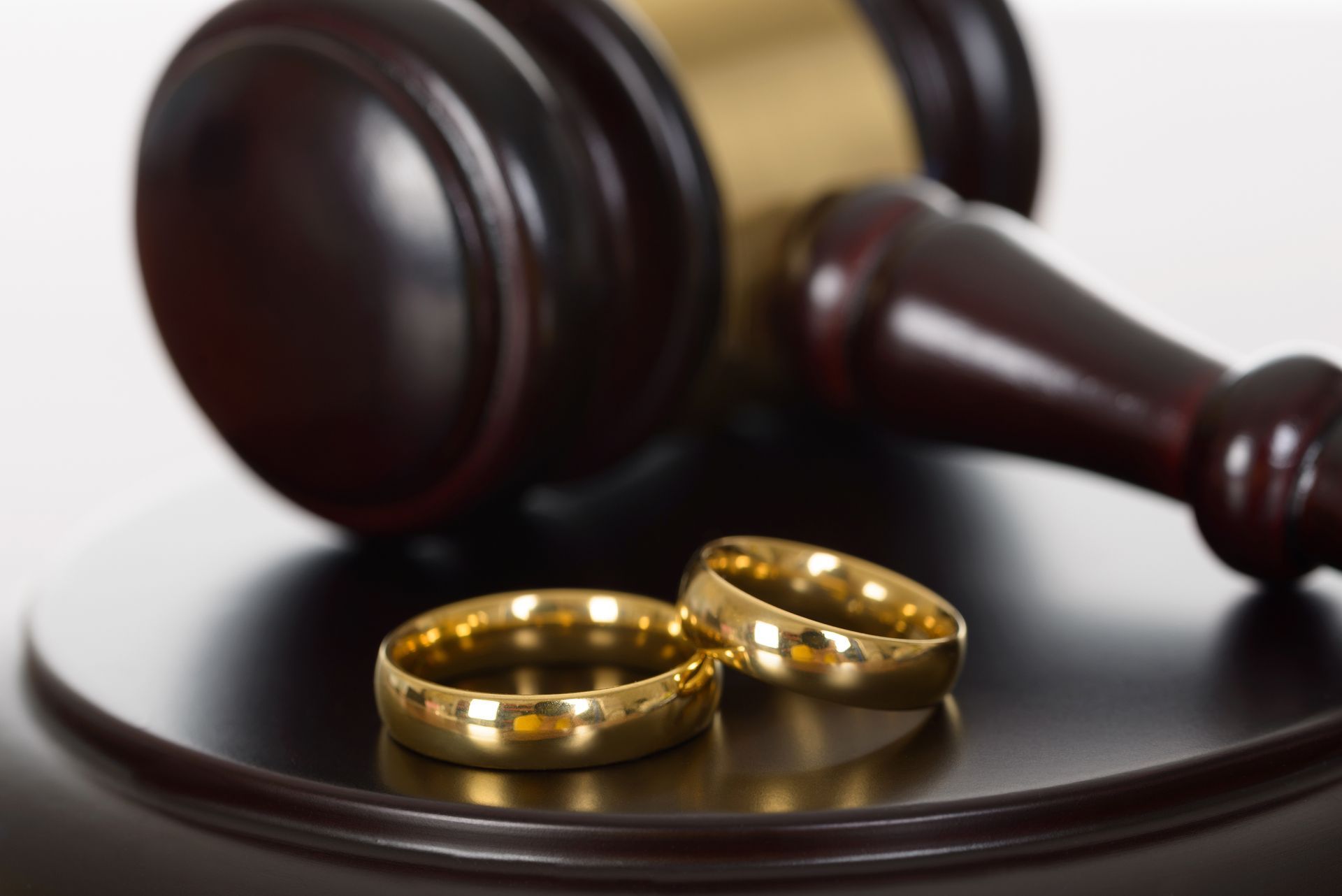 Close-up Of Wedding Rings And Wooden Gavel.