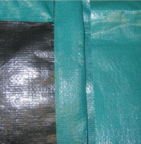 Primo piano di un telo verde acqua. Sezione del telo nero visibile sulla sinistra.
