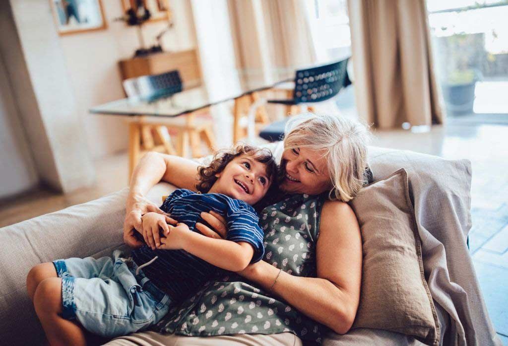 Two people cuddling on a couch in a bright living room